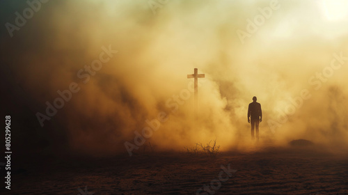 Silhouette of a man in the desert with a cross in the smoke and dust under light the sun, religion concept.   © theevening