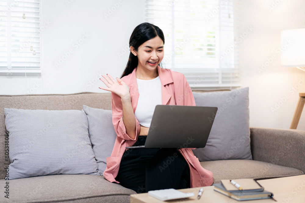 A woman is sitting on a couch with a laptop in front of her A woman is sitting on a couch with a laptop in front of her