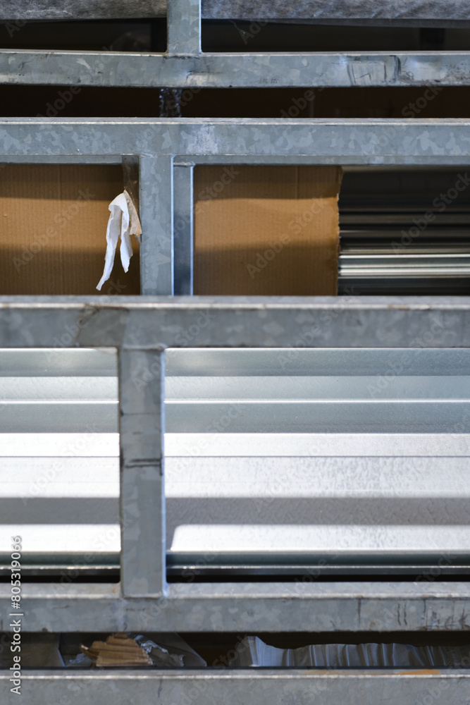 Obraz premium Metal steel square piping pipes stacked up on an industrial heavy duty racking in an industrial factory environment.steel and metal bending fabricators industry. Industrial labour.