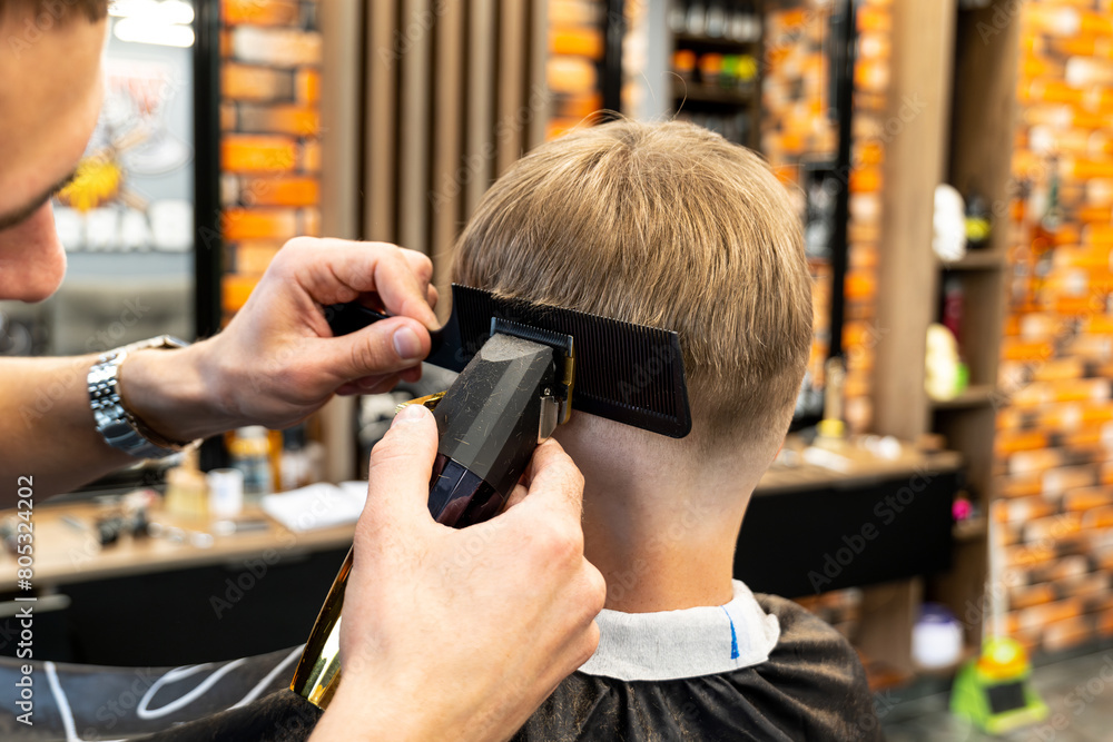 Barber trim hair with clipper on young unshaven man in barbershop studio.Professional hairdresser cut hair with electric shearer machine on guy. Male beauty treatment process Barber trim hair with clipper on young unshaven man in barbershop studio.Professional hairdresser cut hair with electric shearer machine on guy. Male beauty treatment process
