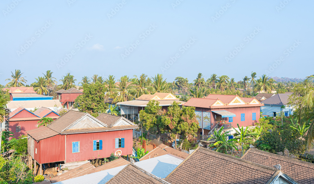 A picturesque village with red tile roofs nestled by the sea under a summer sky