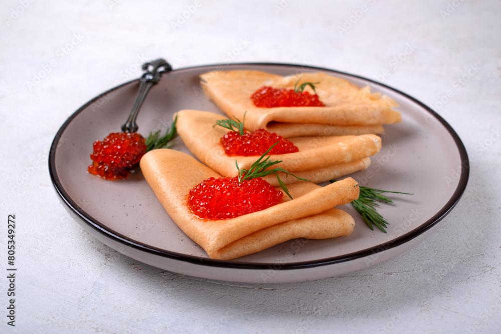 Sourdough crepes with red caviar served on plate. Russian food. Celebrating Shrovetide Sourdough crepes with red caviar served on plate. Russian food. Celebrating Shrovetide