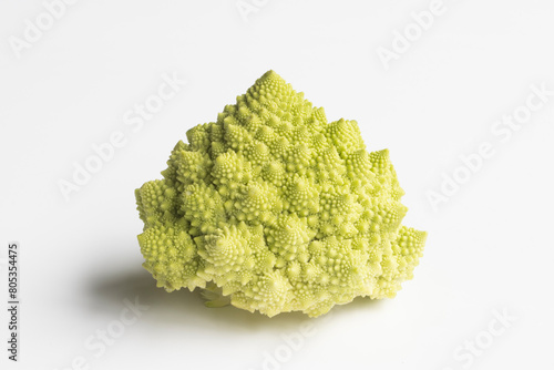 Closeup of a whole head of Romanesco cauliflower (also known as broccolo romanesco, romanesco broccoli, romanesque cauliflower) without leaves isolated on a white background. photo