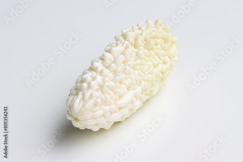 A fresh white bitter melon isolated on a white background. Bitter melon (Momordica charantia) is a tropical and subtropical vine of the family Cucurbitaceae grown for its edible fruit.