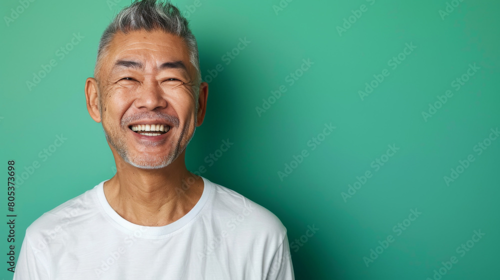 Fototapeta premium A man with a white shirt and gray hair is smiling and looking at the camera