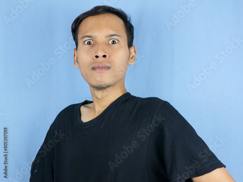 Angry young Asian man expression with pointing gesture and bulging eyes. Mental health concept