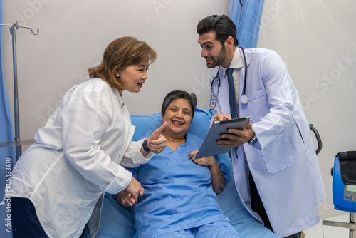 Doctor Visiting Patient On Ward. Hospitalized man lying in bed while doctor checking his. physician examining patient in hospital room. Hospital Ward