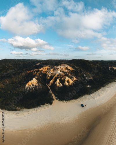 Aerial Drone view of The Pinnacles, Colored Sands on Fraser Island, Sunrise with car. Kgari, Queensland, Australia. photo