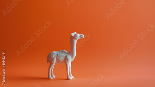 A cute camel figurine on an orange background  in a minimalist style with a simple design. Copy space for text