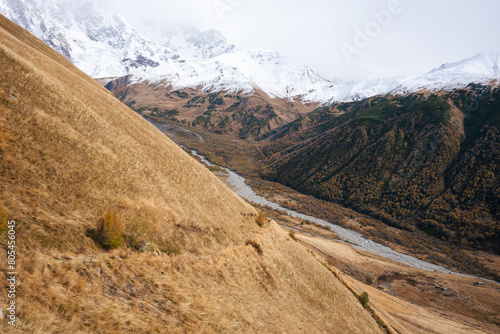The Contrast of Golden Hills and Verdant Valleys Under the Snowy Peaks of the Caucasus