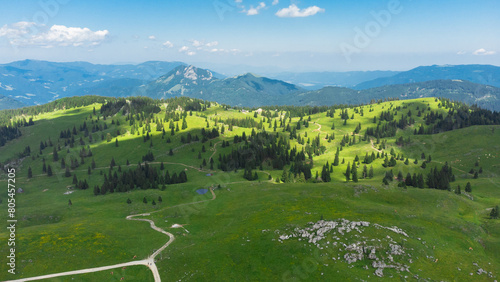 Aerial View of Mountain Cottages on Green Hill of Velika Planina Big Pasture Plateau, Alpine Meadow Landscape, Slovenia photo
