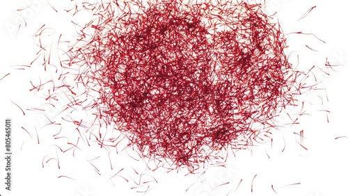 Red saffron threads falling on a white surface