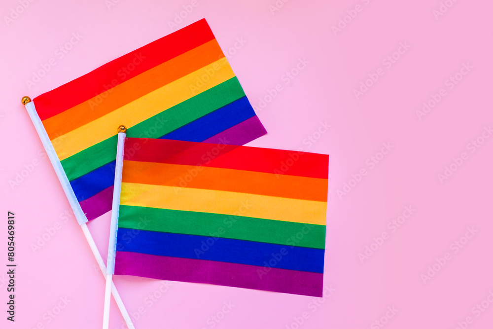 LGBT rainbow flag flat lay on light pink color background. gay marriage, human rights, june parade, lgbtq proud history month concept, coming out day. top view, place for text or logo LGBT rainbow flag flat lay on light pink color background. gay marriage, human rights, june parade, lgbtq proud history month concept, coming out day. top view, place for text or logo