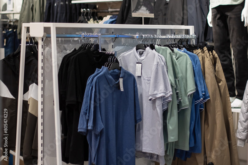 a row of shirts are hanging on a rack in a store