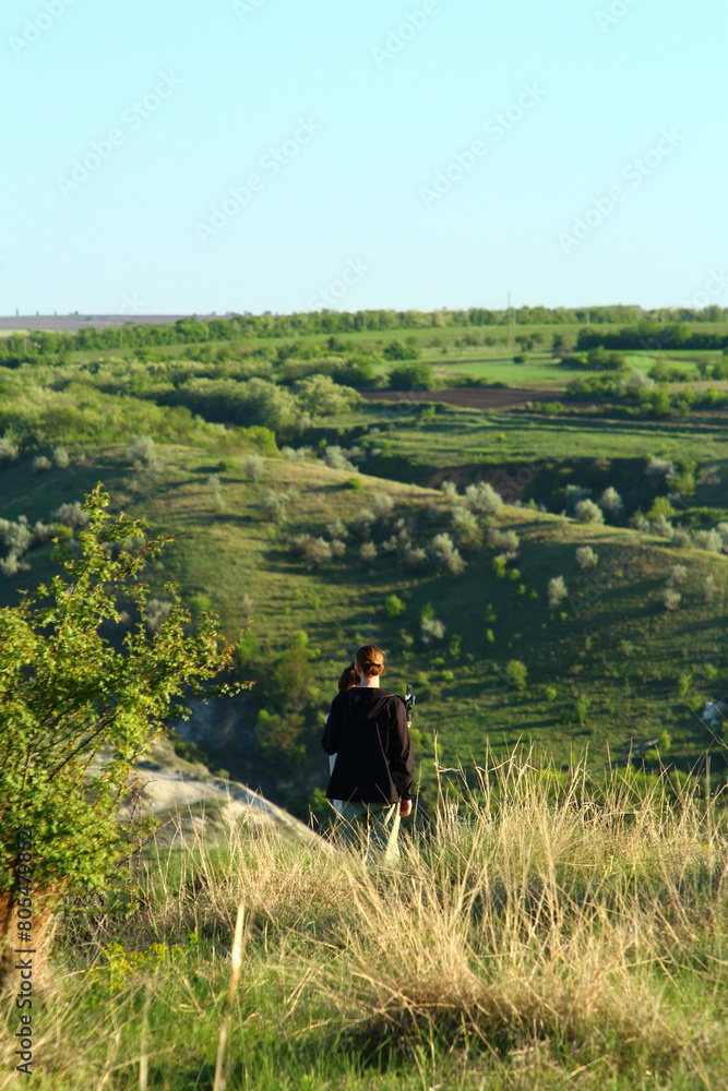 A man and woman walking on a path in a grassy field A man and woman walking on a path in a grassy field