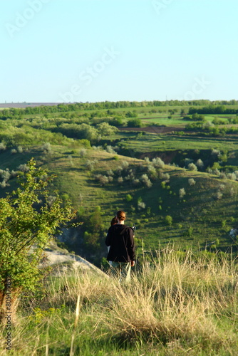 A man and woman walking on a path in a grassy field