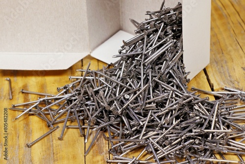 Small metal nails are scattered near the box.