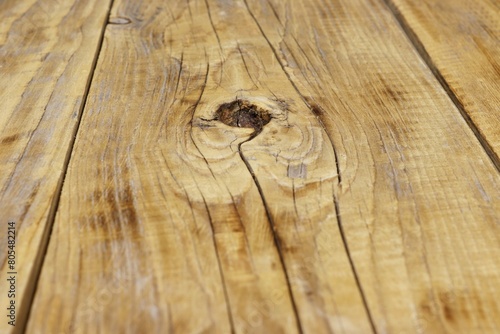 A hole in a wooden board after a fallen knot.