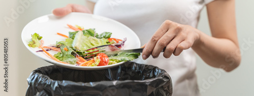 Photos Compost from leftover food in the meal in household, female hand holding left over meal use fork scraping waste, rotten vegetable throwing away into garbage, trash or bin