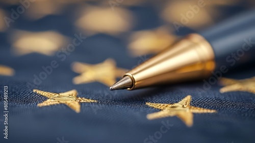  A pen atop a blue cloth; gold stars beside it Pen's tip touches fabric