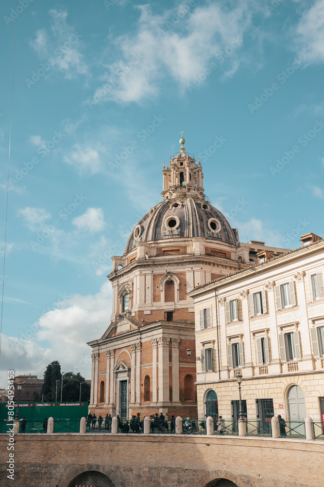 A stately building rises prominently, adorned with a striking dome at its pinnacle. The structure commands attention and exudes grandeur against the backdrop of the sky