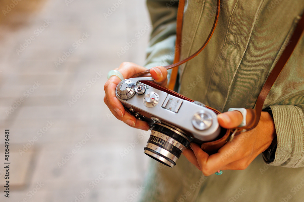 girl with a camera. the photographer adjusts the camera. Stylish girl with a film camera. film camera close up.