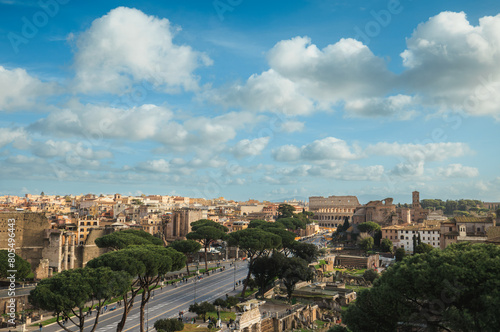 From a lofty hill, the sprawling city of Rome unfolds below – ancient ruins, bustling streets, and majestic architecture blend seamlessly under the blue sky