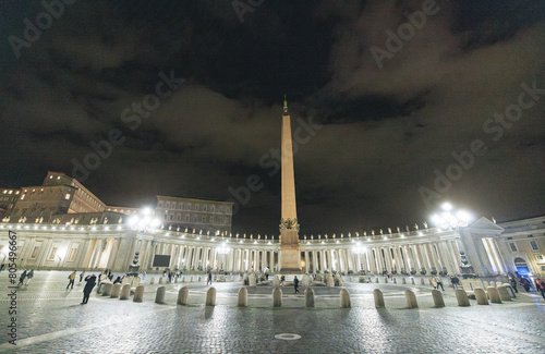 A grand, majestic building with a towering spire in the center, reaching towards the sky. The structure exudes power and elegance, dominating the surrounding landscape with its impressive presence