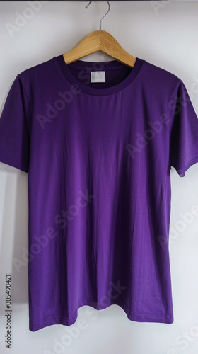 A deep purple t-shirt displayed on a polished wooden hanger, with a stark white environment emphasizing the richness of the color 