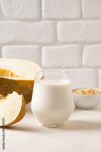 Alternative melon seeds milk and seeds on white background. Close up. Vegan fruit based milk.