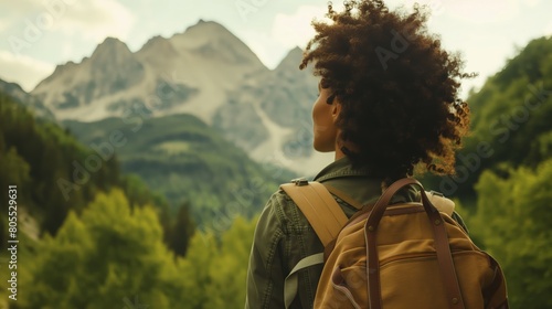 A Black woman with backpack admiring mountain range