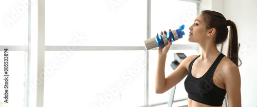Sporty young woman drinking...