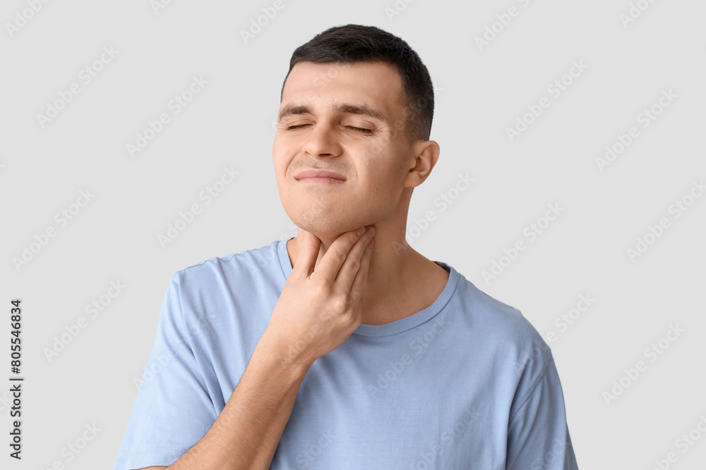 Young man suffering from sore throat on light background, closeup Young man suffering from sore throat on light background, closeup