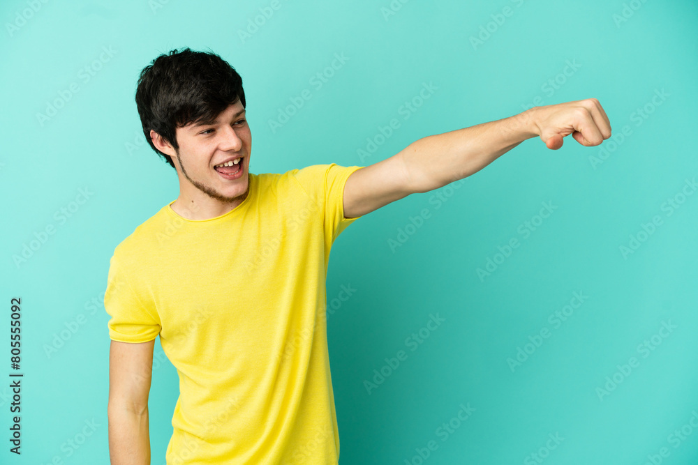 Young Russian man isolated on blue background giving a thumbs up gesture Young Russian man isolated on blue background giving a thumbs up gesture