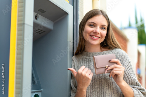 Young pretty blonde woman using an ATM