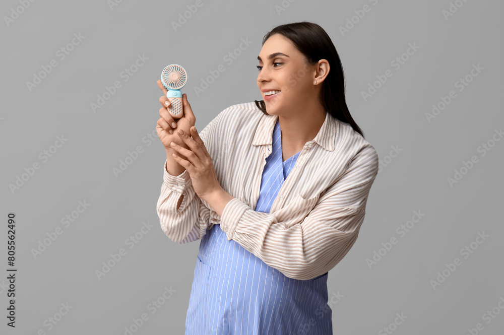 Pregnant young woman with small electric fan on white background Pregnant young woman with small electric fan on white background