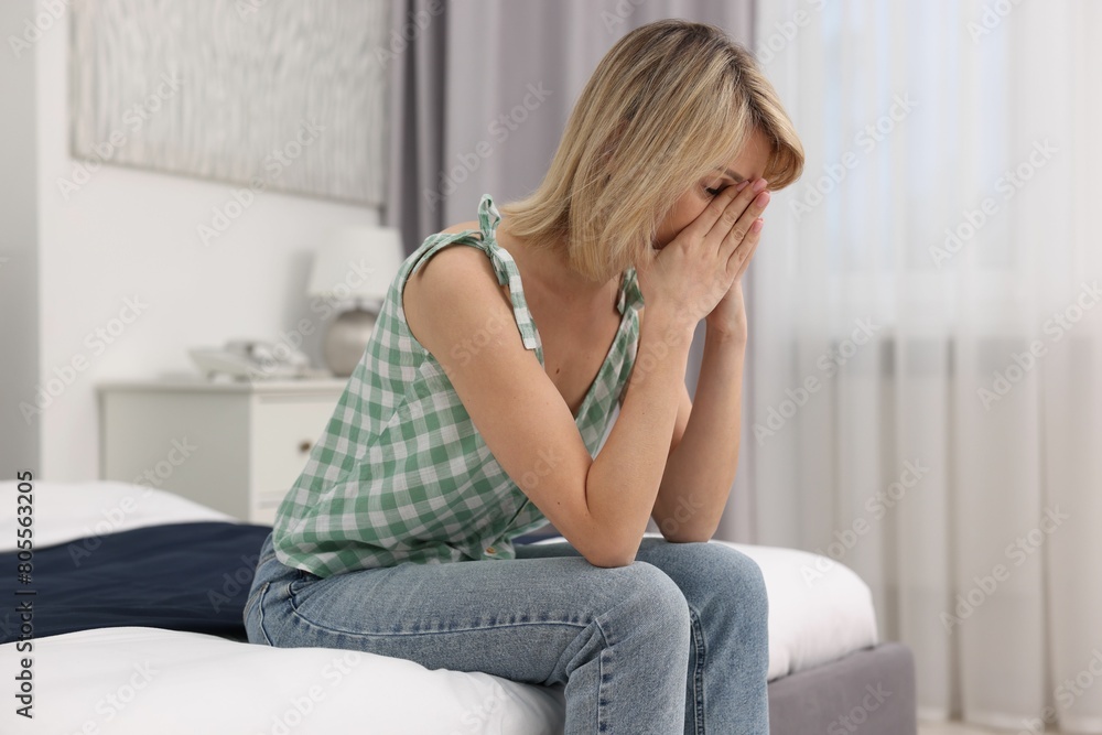 Overwhelmed woman covering face with hands at home Overwhelmed woman covering face with hands at home