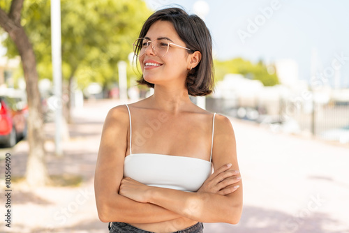 Young pretty Bulgarian woman with glasses at outdoors happy and smiling Free Download Young pretty Bulgarian woman with glasses at outdoors happy and smiling - GFXLoad