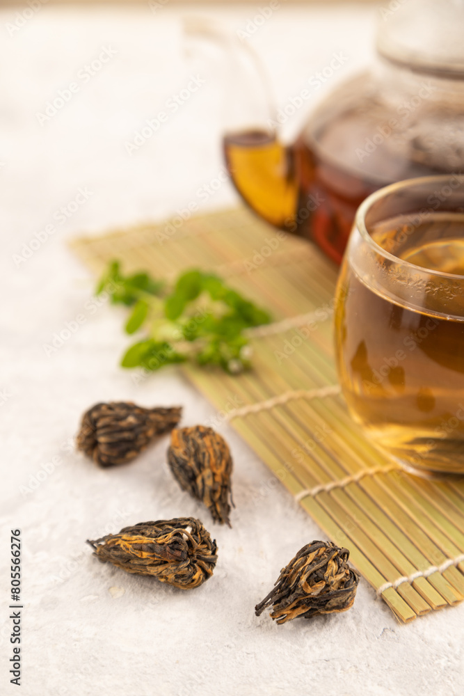 Red tea with herbs in glass on gray concrete. Side view, selective focus. Red tea with herbs in glass on gray concrete. Side view, selective focus.
