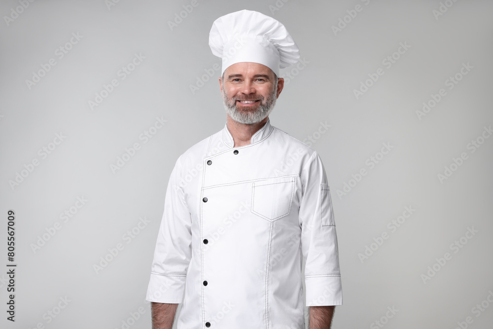 Happy chef in uniform on grey background Happy chef in uniform on grey background