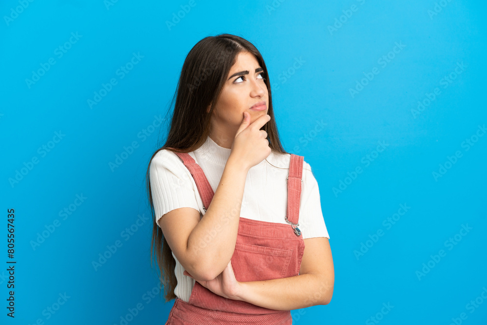 Young caucasian woman isolated on blue background having doubts Young caucasian woman isolated on blue background having doubts