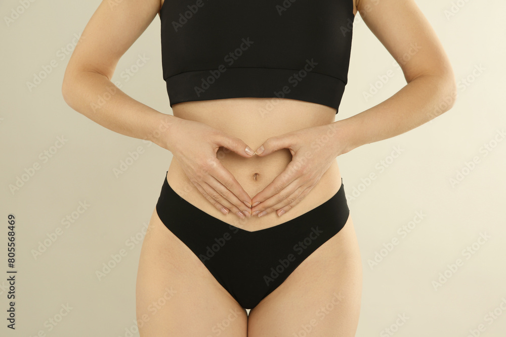 Gynecology. Woman in underwear making heart with her hands on light background, closeup Gynecology. Woman in underwear making heart with her hands on light background, closeup