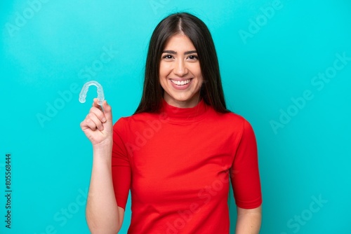 Young caucasian woman holding a envisaging isolated on blue background smiling a lot