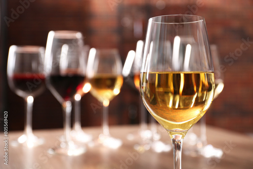 Tasty white wine in glass against blurred background, space for text