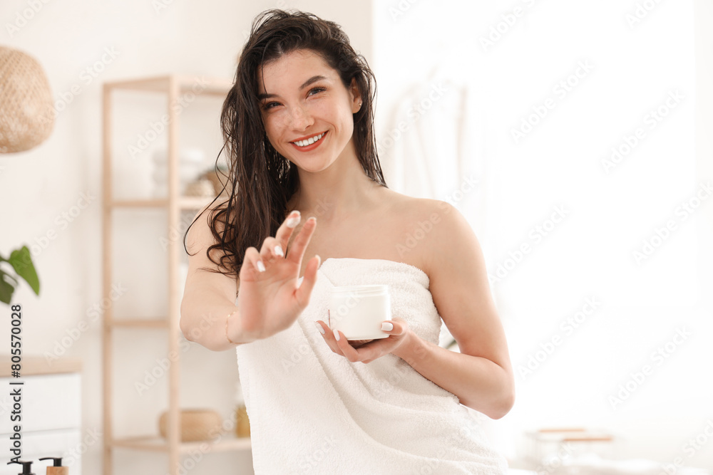 Beautiful young happy woman with jar of hair mask in bathroom at home Beautiful young happy woman with jar of hair mask in bathroom at home