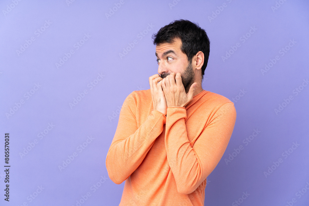 Caucasian handsome man over isolated purple background nervous and scared putting hands to mouth Caucasian handsome man over isolated purple background nervous and scared putting hands to mouth