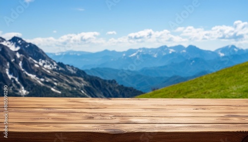 empty wooden tabletop close up against the backdrop of a mountain range © Charlotte