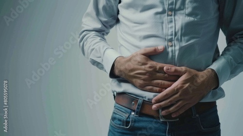 This striking image captures a close-up view of a man holding his large belly, set against a vibrant yellow background, highlighting metabolic issues, heartburn and bloating. photo