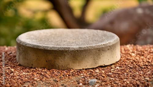 a concrete moulding showing a very old semi circle base with imprints and grit to the surface for a product display with a natural stone blurred foreground and background