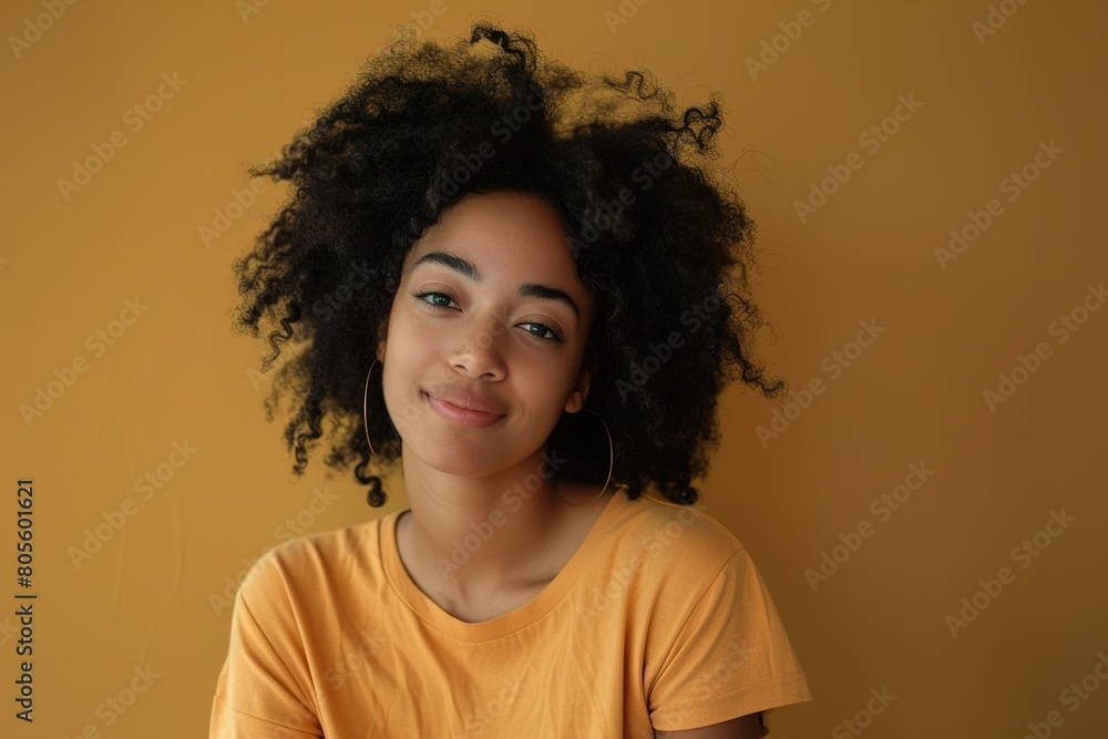 A woman with curly hair is wearing a yellow shirt and smiling A woman with curly hair is wearing a yellow shirt and smiling
